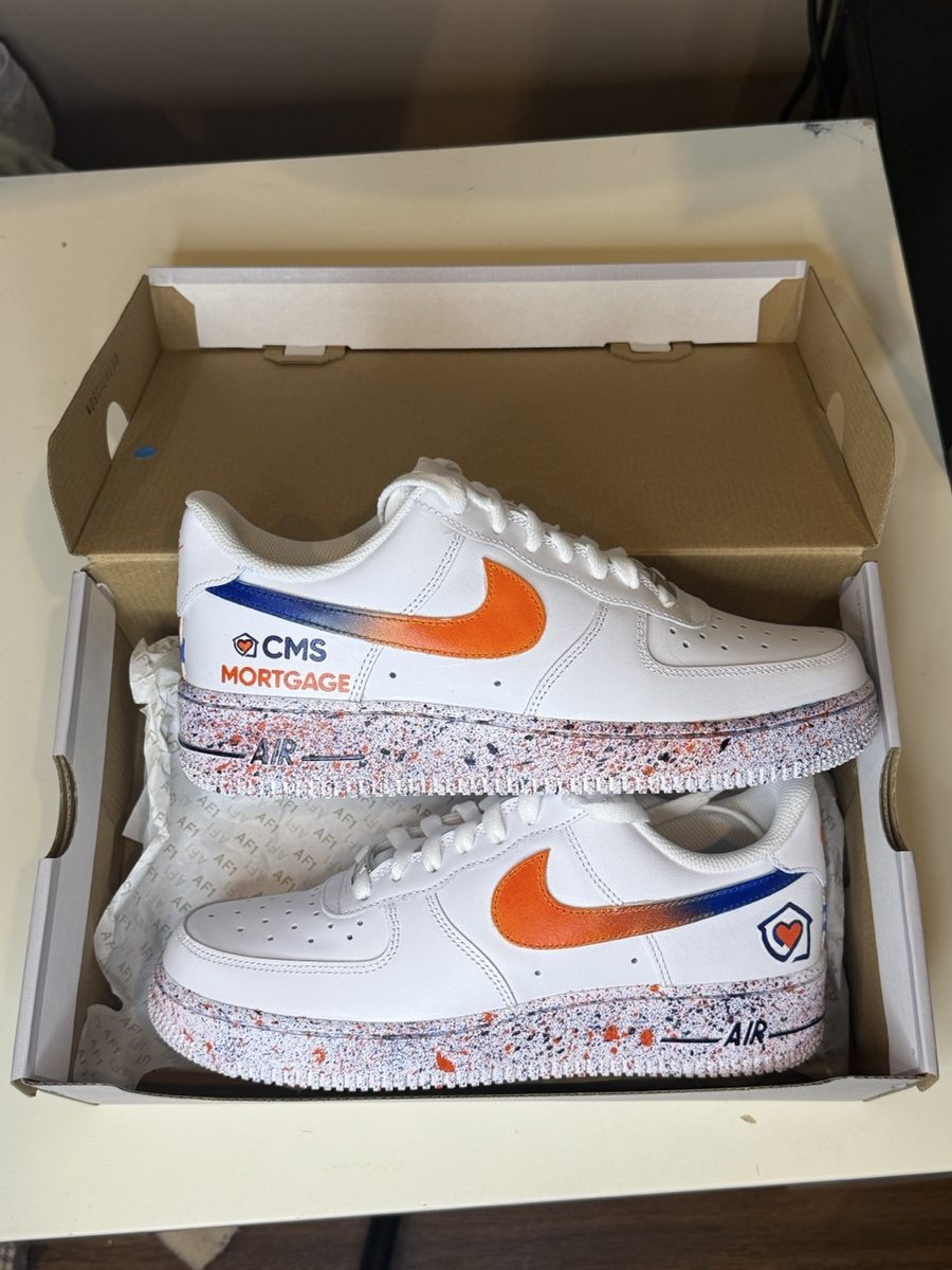 Orange and blue sneakers painted with a company logo